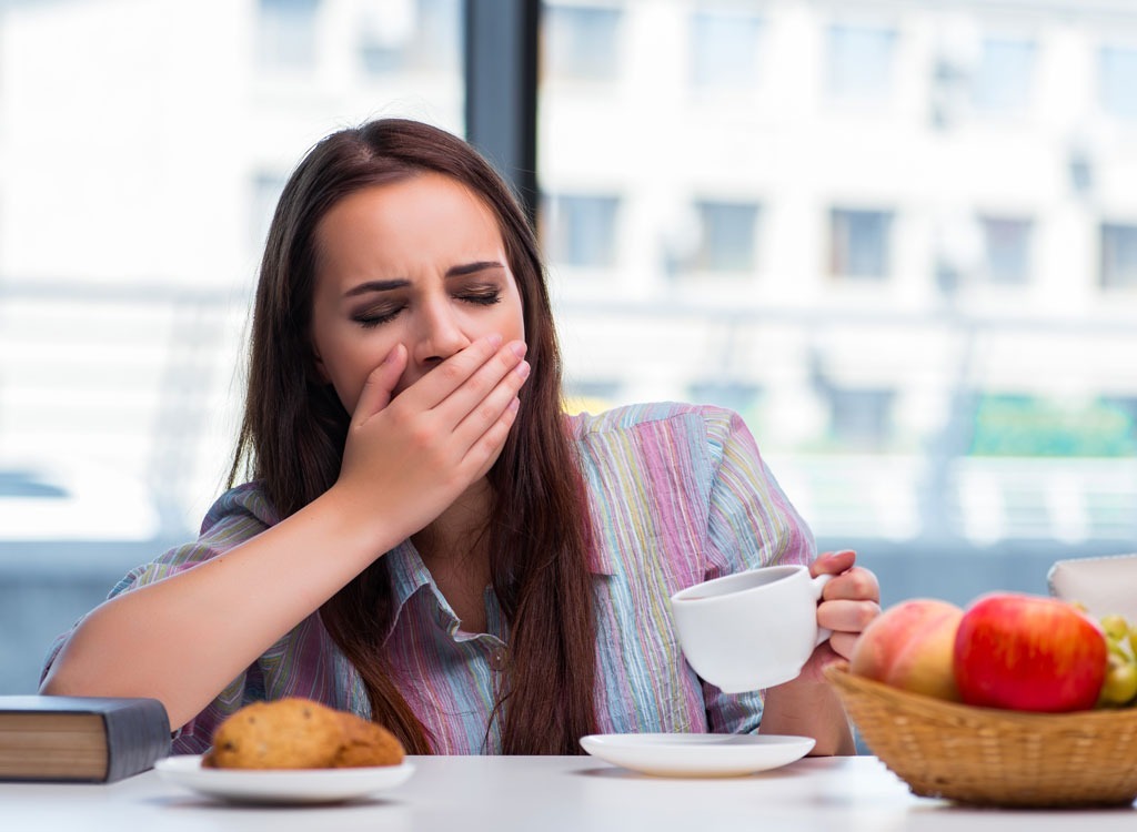 sleepy woman eating breakfast