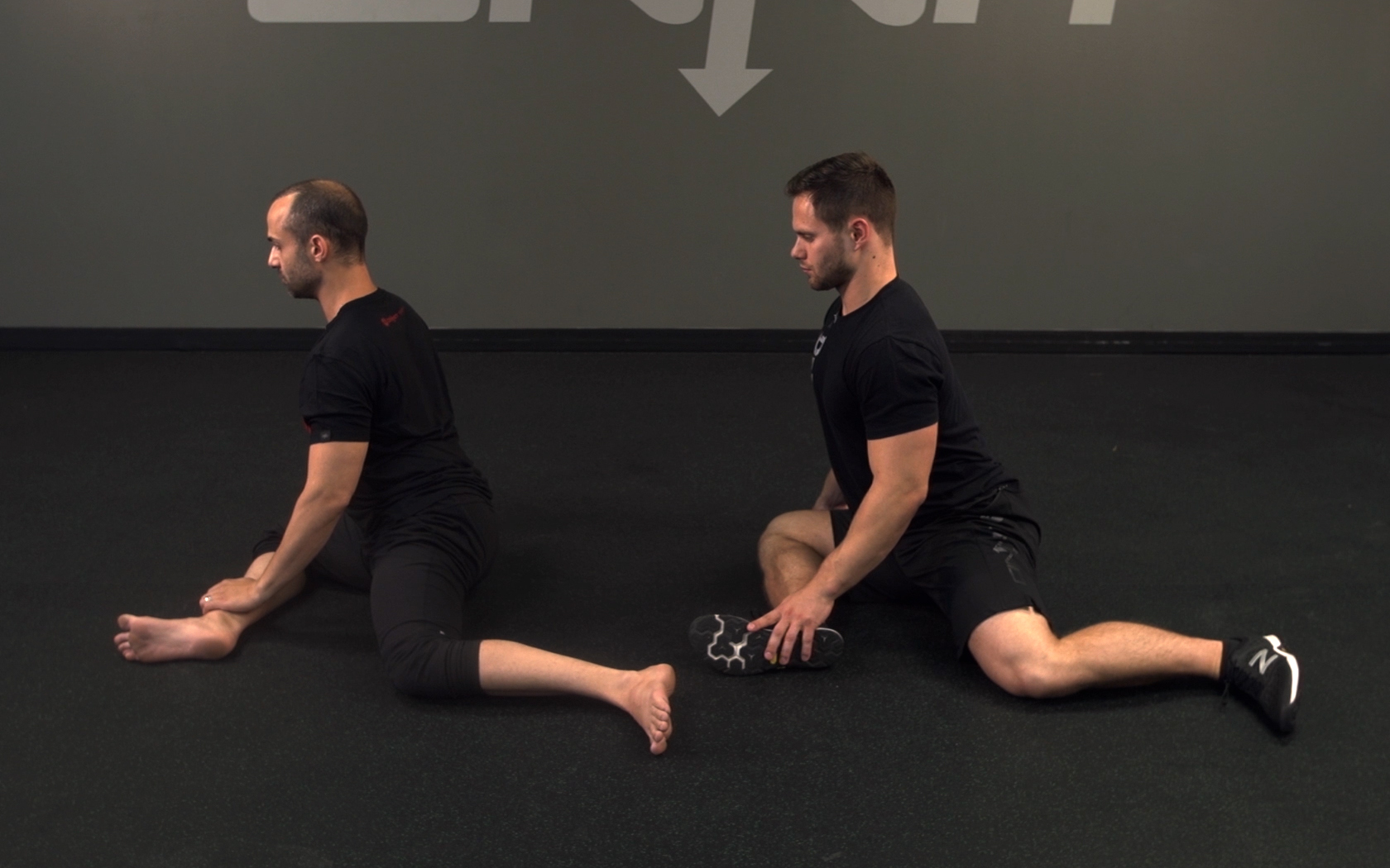 two men show 90/90 exercise for hip joint flexibility. 