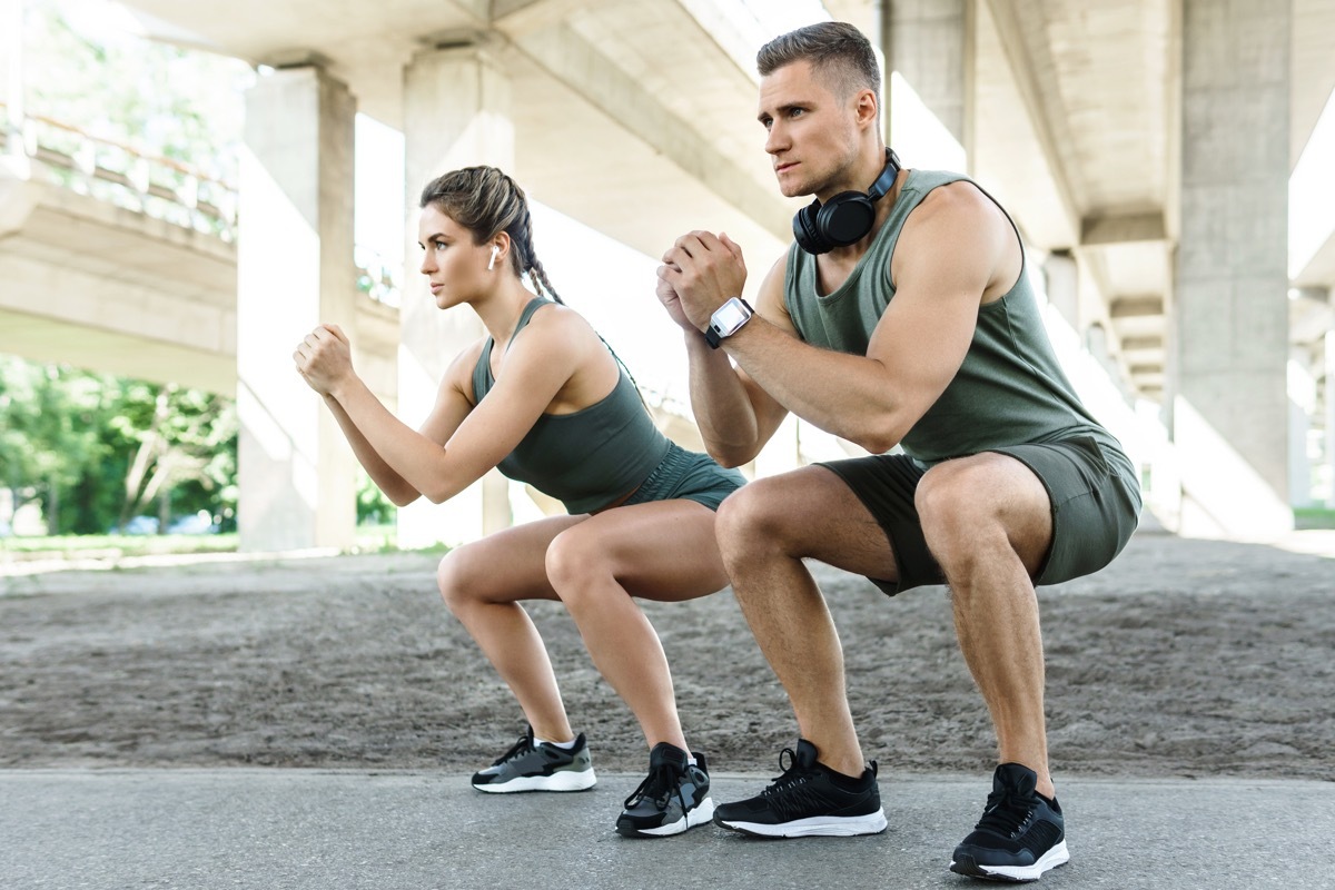 Man and Woman Doing Squats Outside