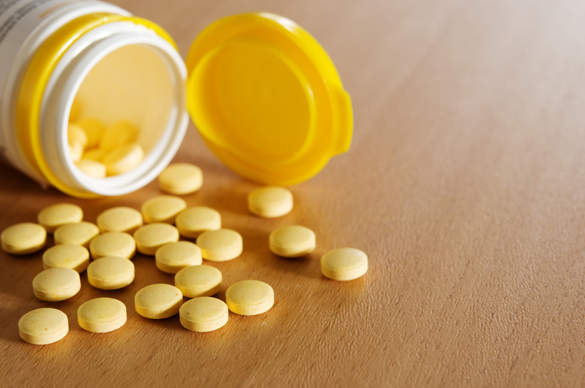 vitamin C pills and plastic bottle on the wooden table