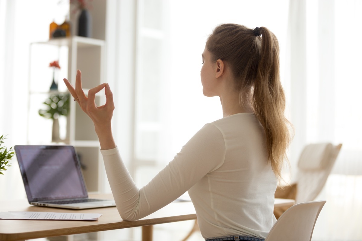 Woman at her desk practicing her posture. 