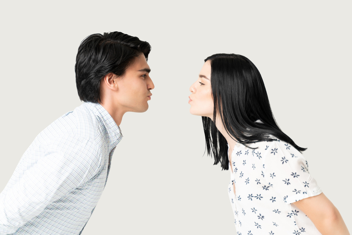 Side view of boyfriend and girlfriend puckering lips while preparing for kiss