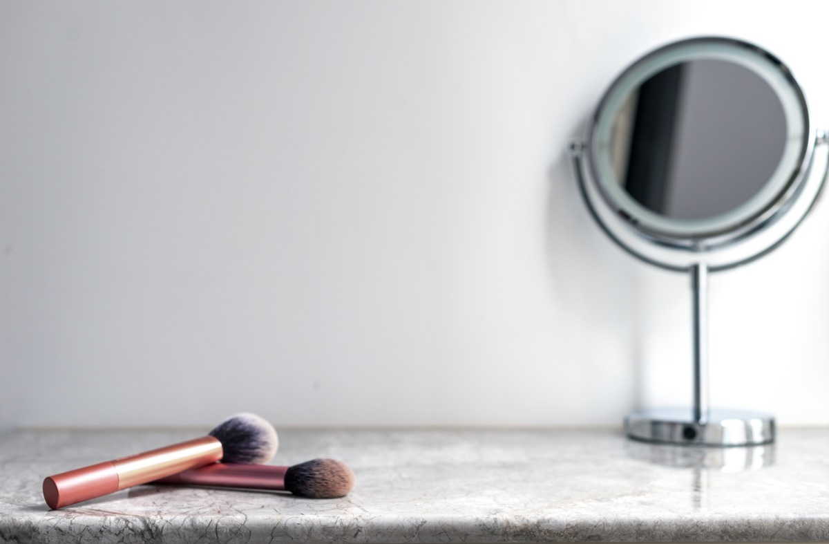 Vanity table with makeup brushes and mirror