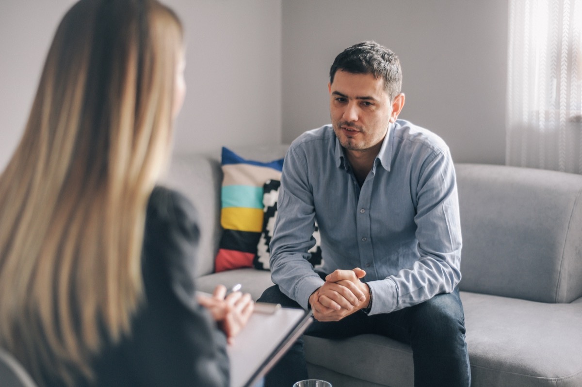 Mid age man talks with a female counselor at home. One on one meeting