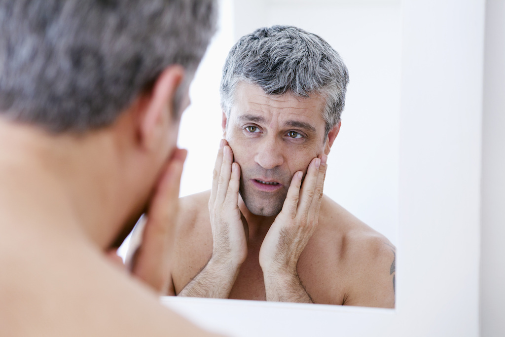 aging man looking in mirror