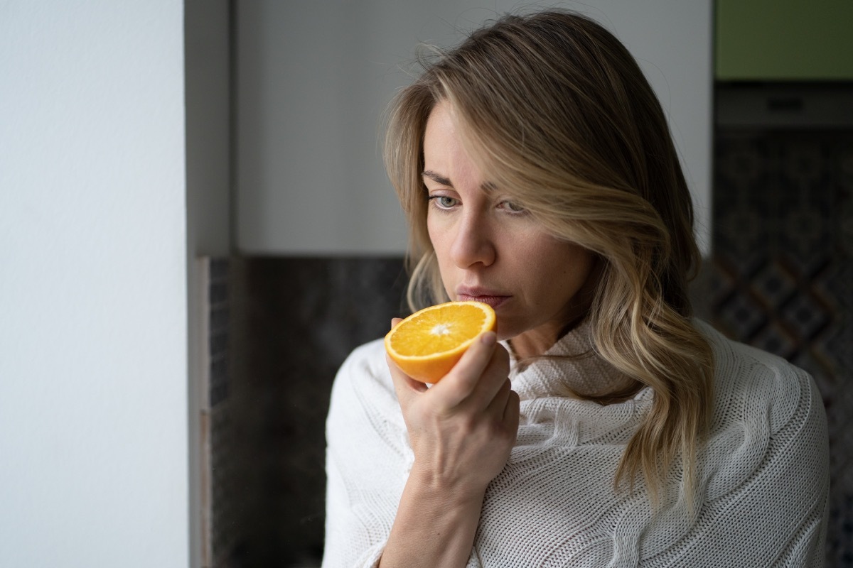 woman trying to smell half an orange