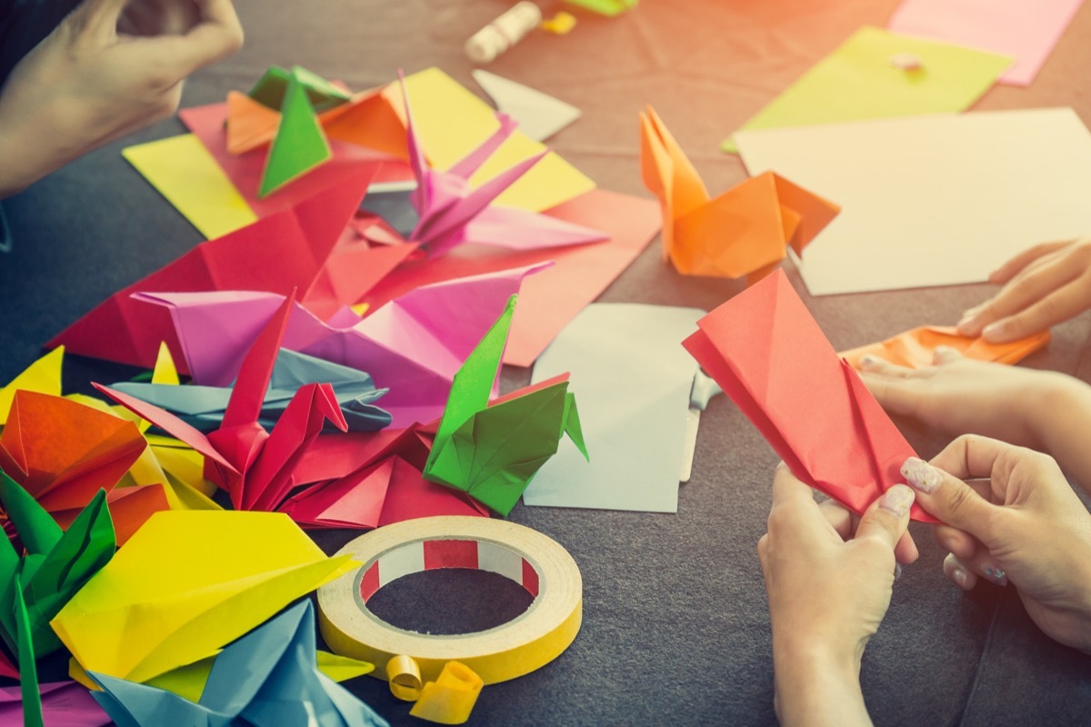 People making origami birds at table