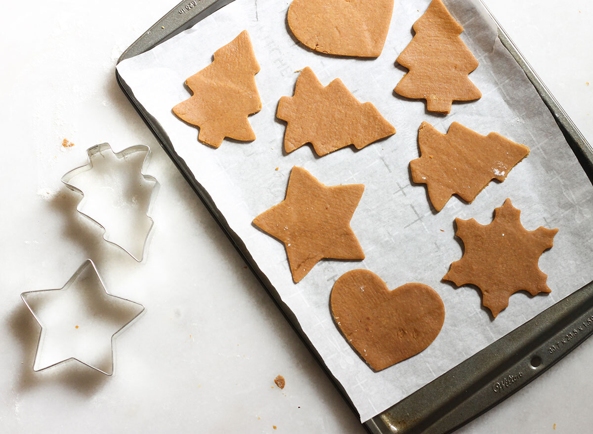 gingerbread cookies cut into shape on a baking sheet ready for the oven