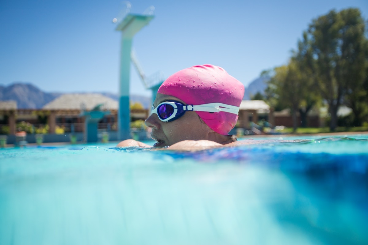 Close up image of a beautiful female swimmer in a swimming pool getting ready to train.