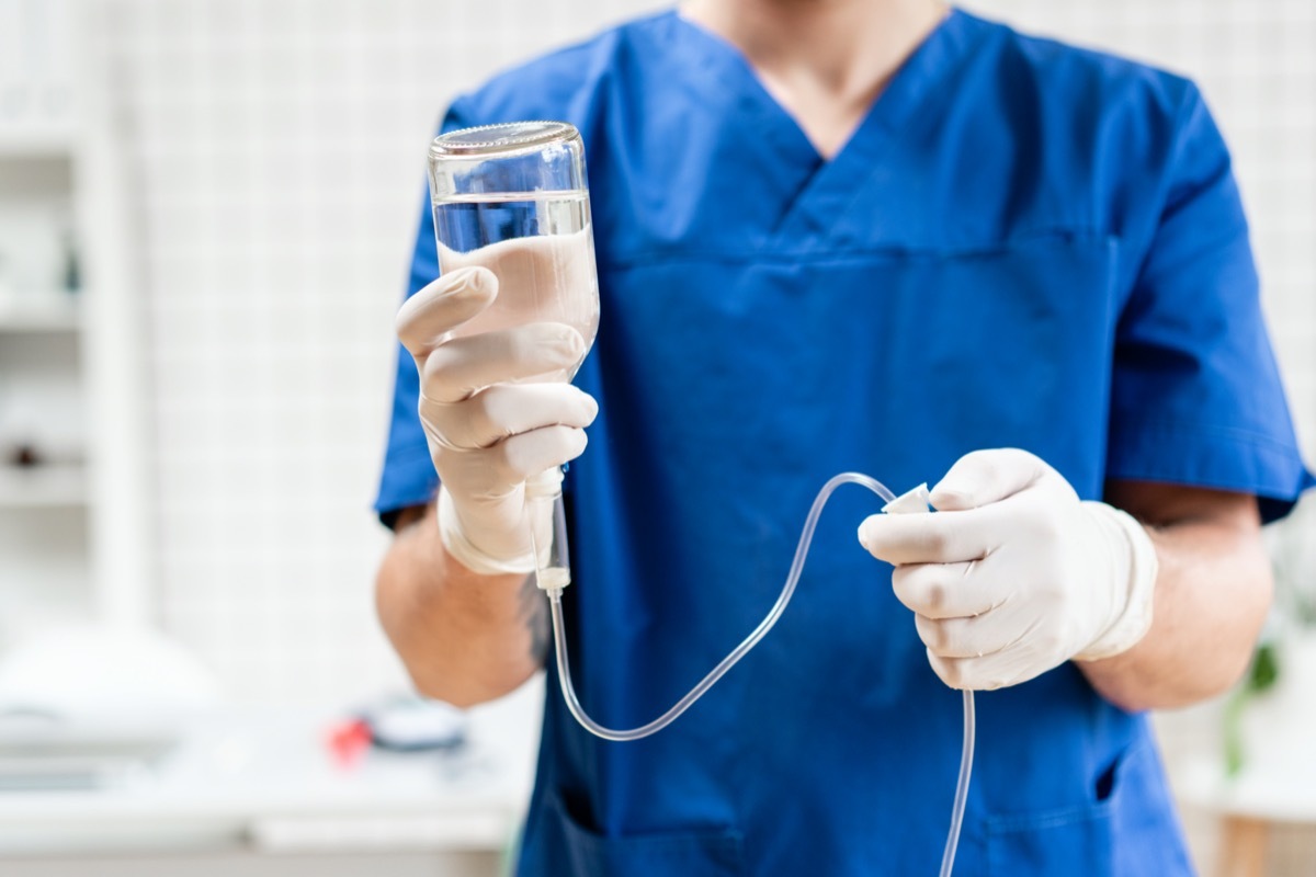 Doctor in blue uniform holding drip iv and infusion pump