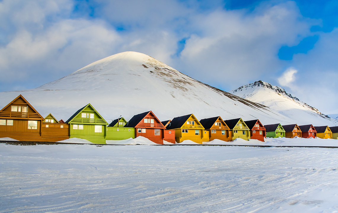 a row of colorful houses in a snowy landscape