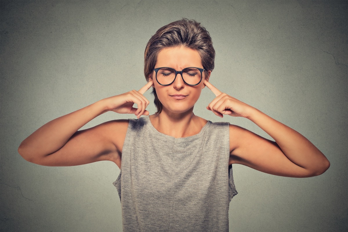 Woman plugging ears with fingers doesn't want to listen