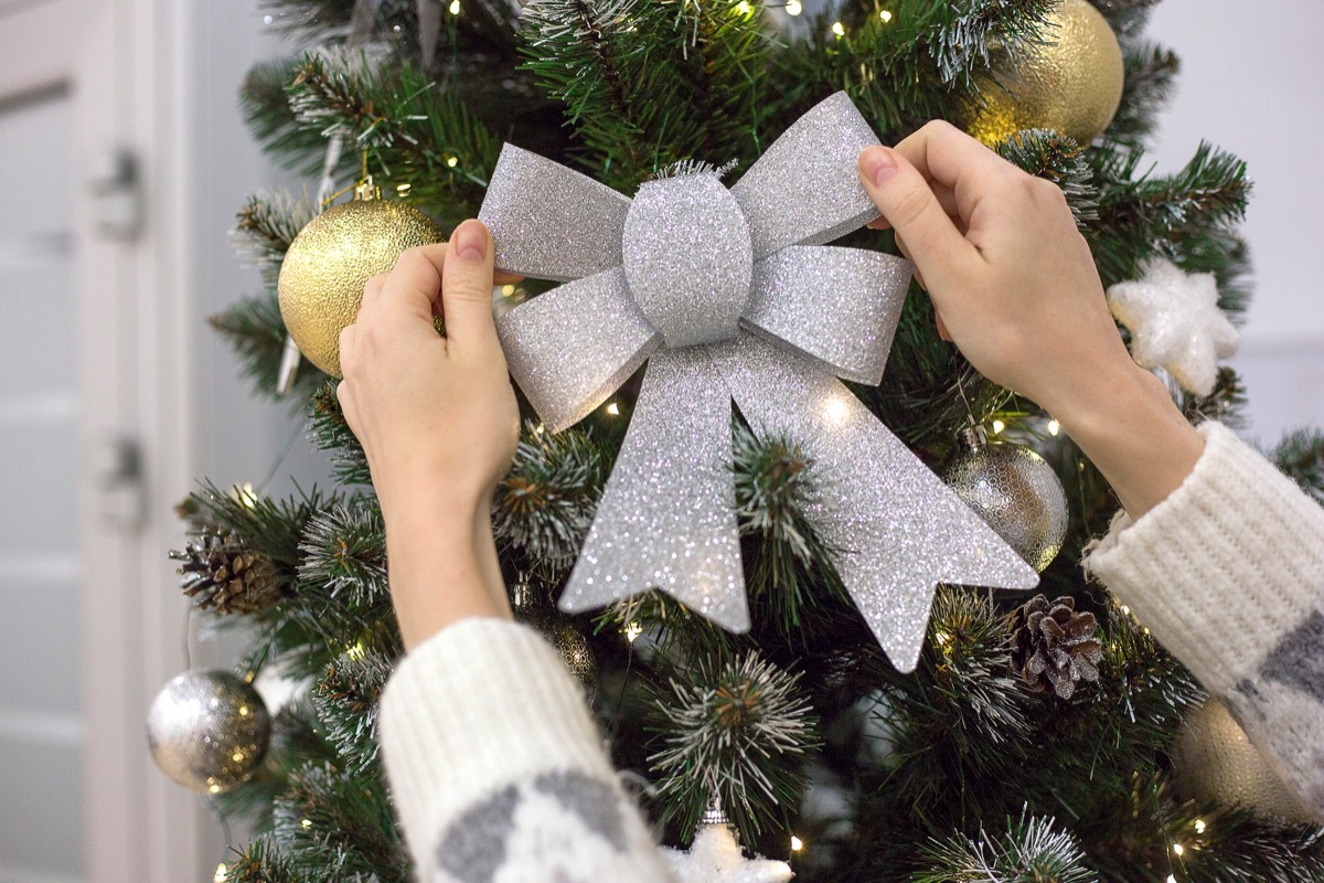 Silver Christmas bow by a Christmas tree