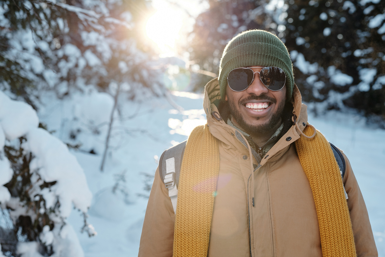 happy young man smiling in winter backdrop