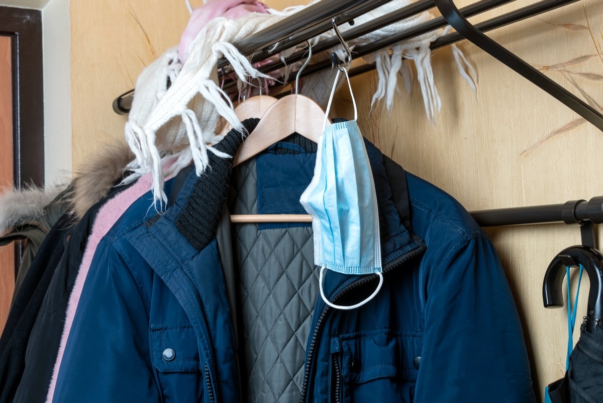 Medical mask on the background of clothes on a hanger in the hallway