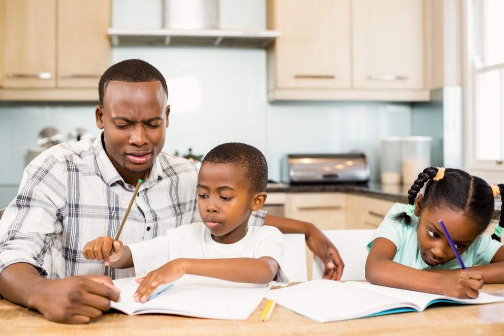 father helping children with schoolwork