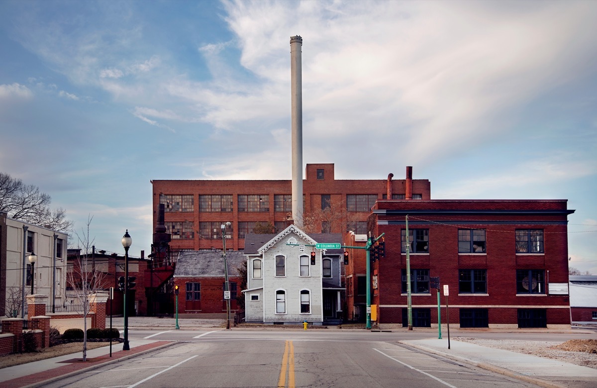 An old house sits in front of a factory in Springfield Ohio