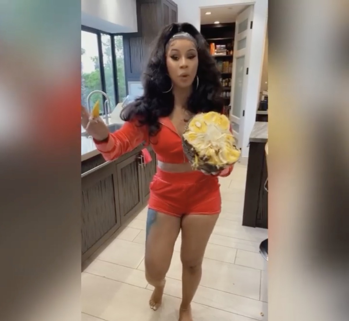 cardi b in red outfit holding jackfruit