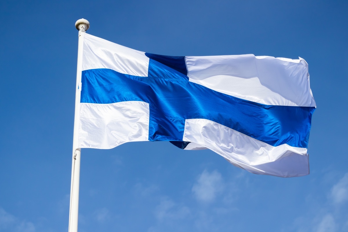 Finnish national flag on the wind against the blue sky