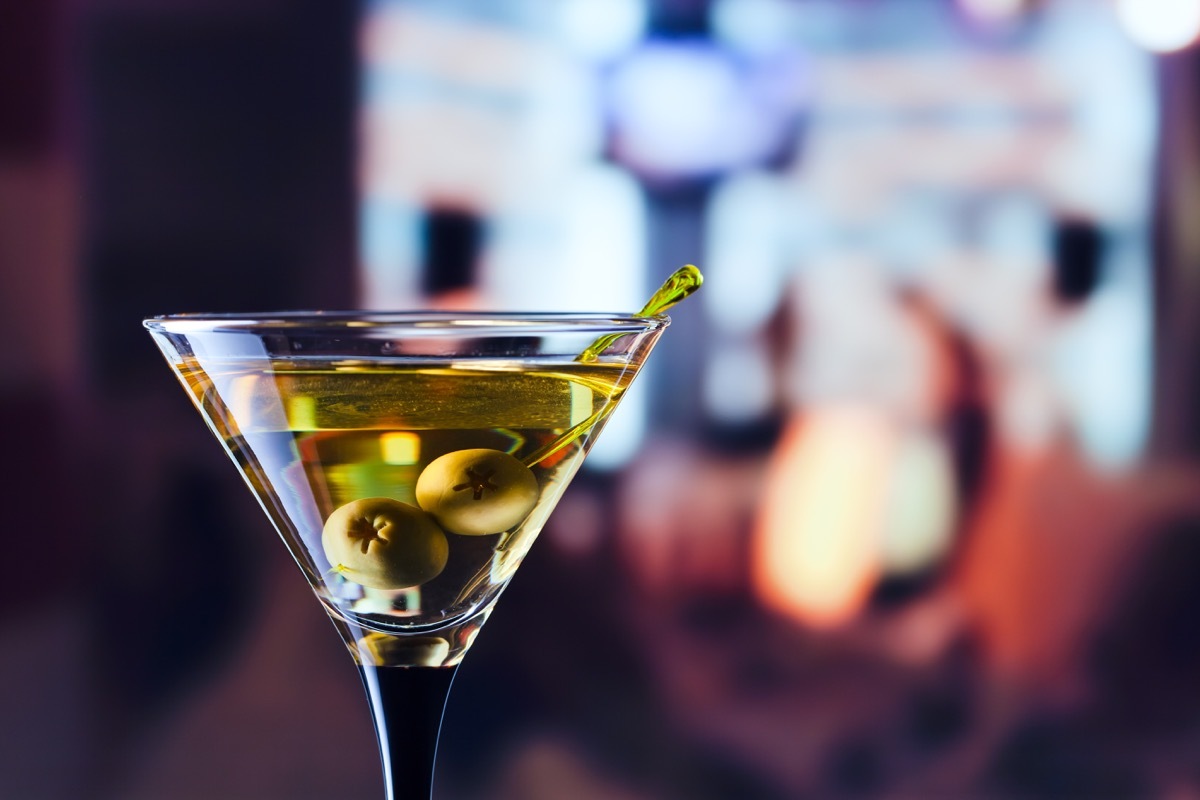 glass with martini , focus on a olives