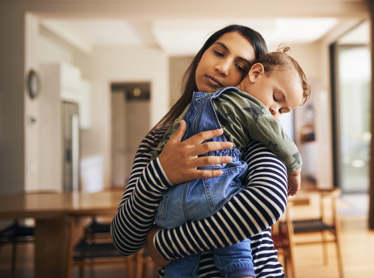 young, tired mom holding her child in her arms