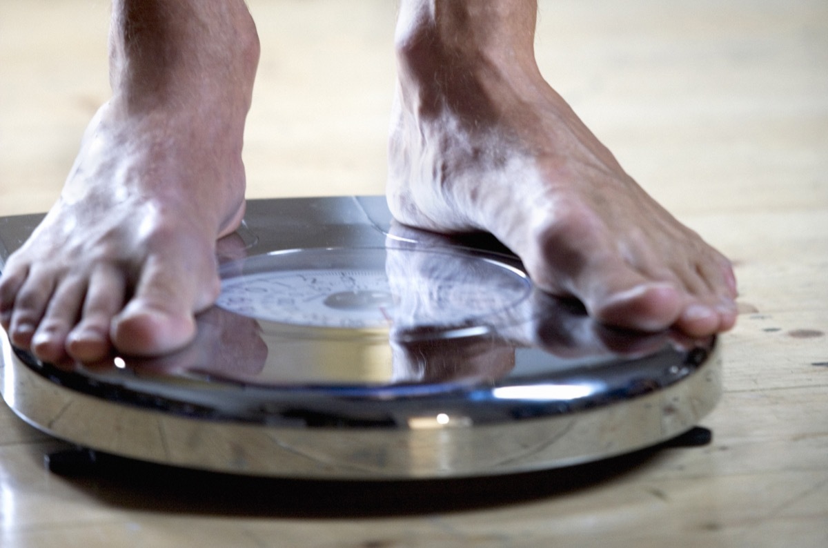 man weighing himself on a scale