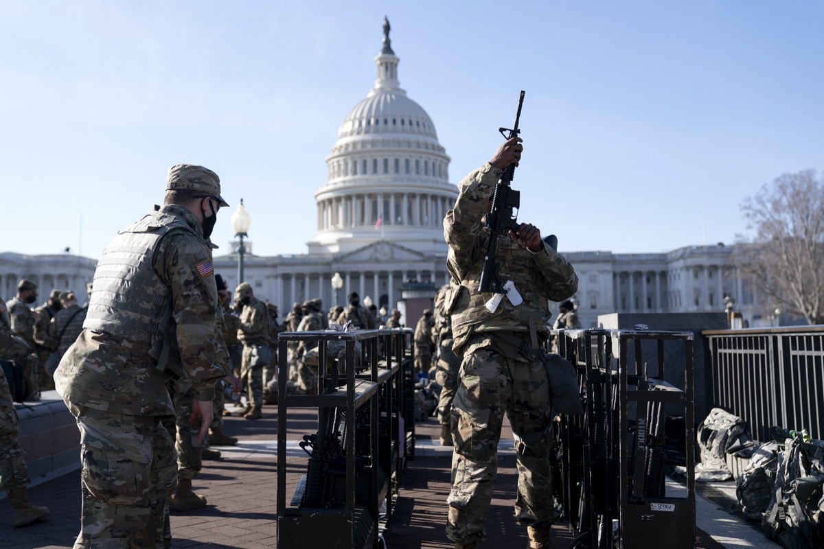 national guard member checks his rifle in front of capitol building