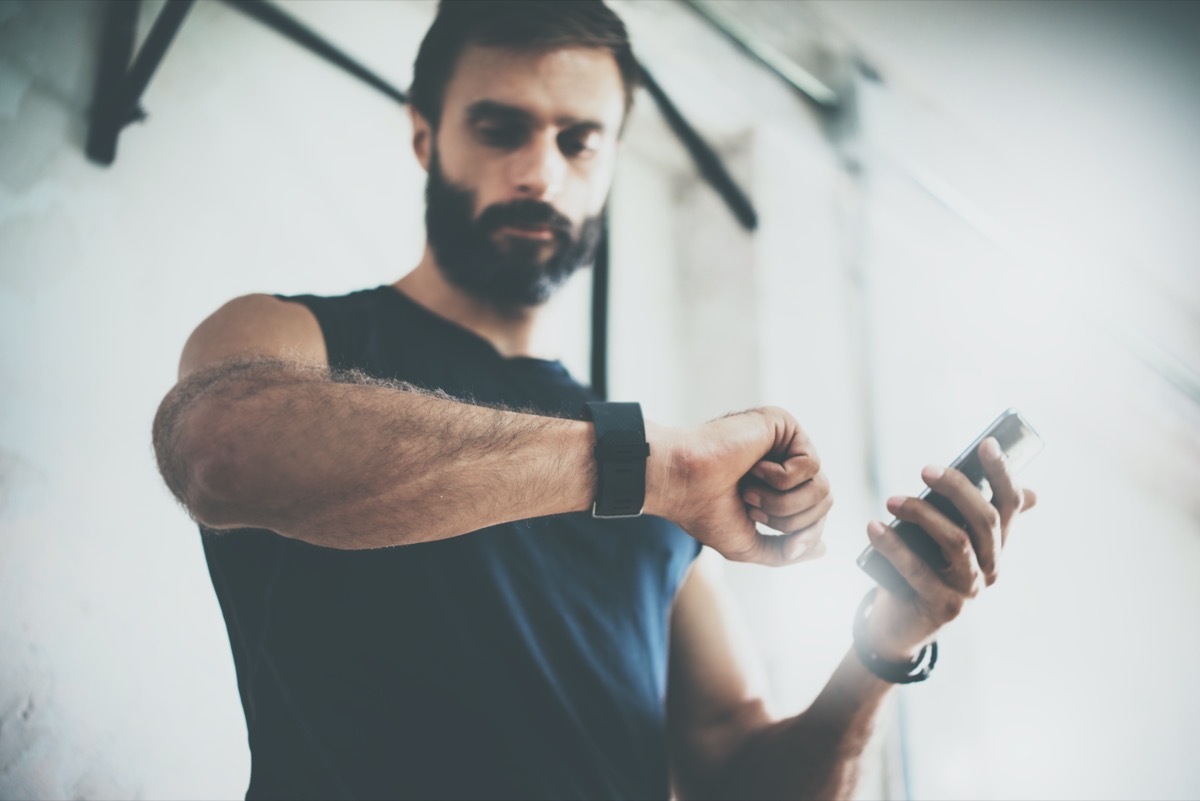 Bearded Sportive Man After Workout Session Checks Fitness Results Smartphone