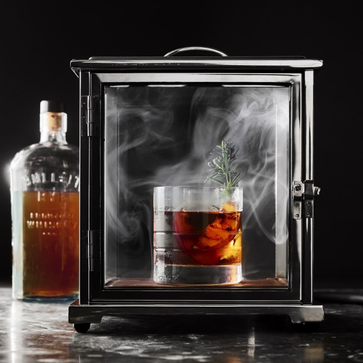 glass of whiskey in a smoky glass box