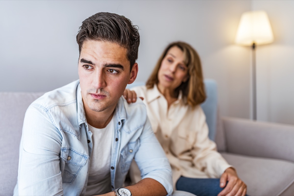 mother trying to talk to her older son as they sit on the couch together