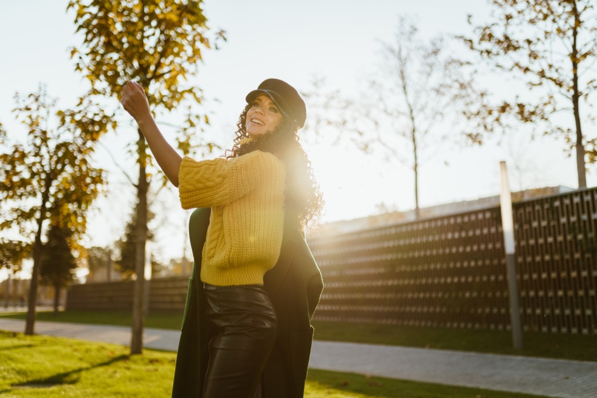 woman wearing sweater and holding jacket in the wall