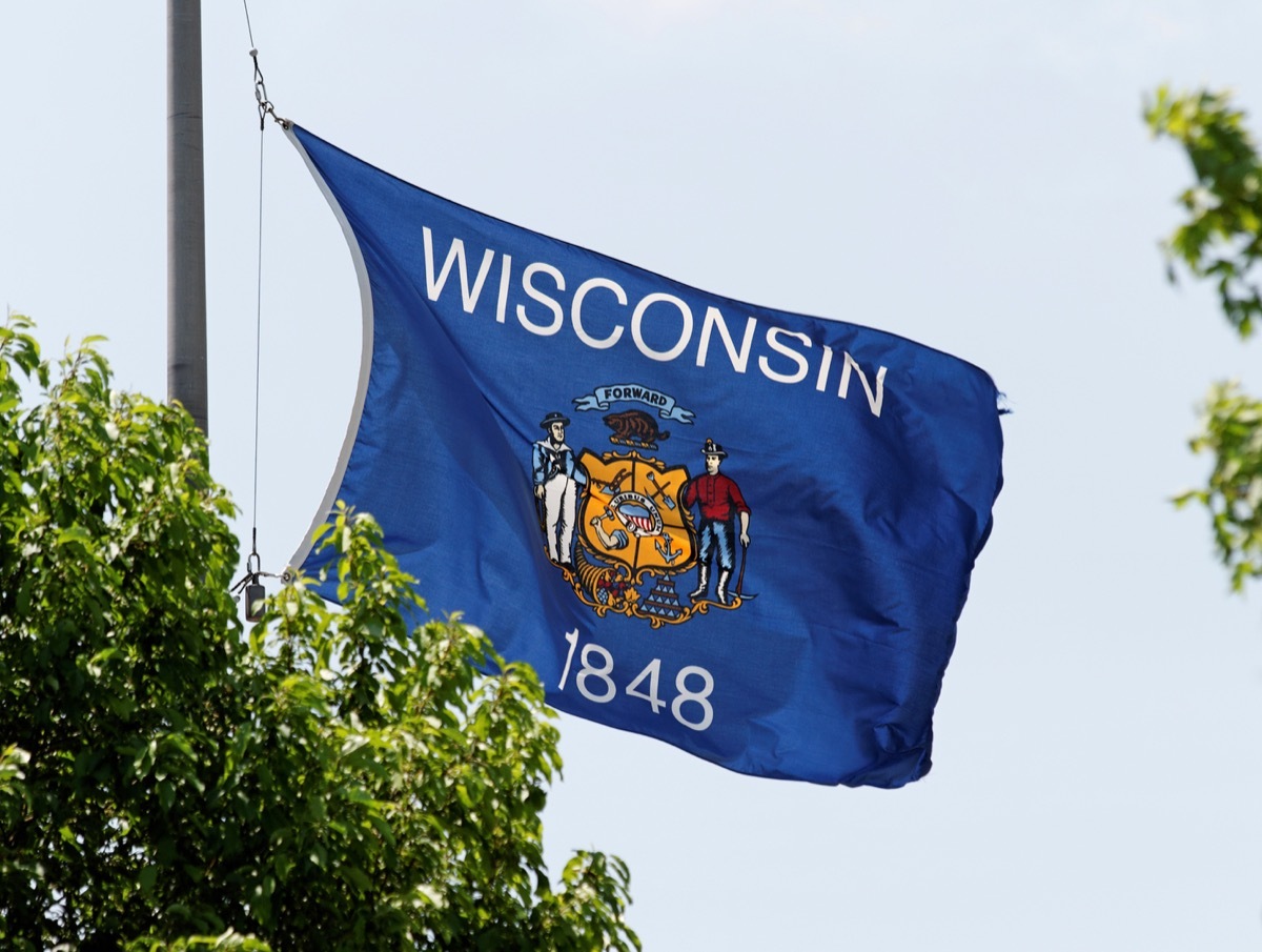 The Wisconsin state flag waving in the wind. - Image