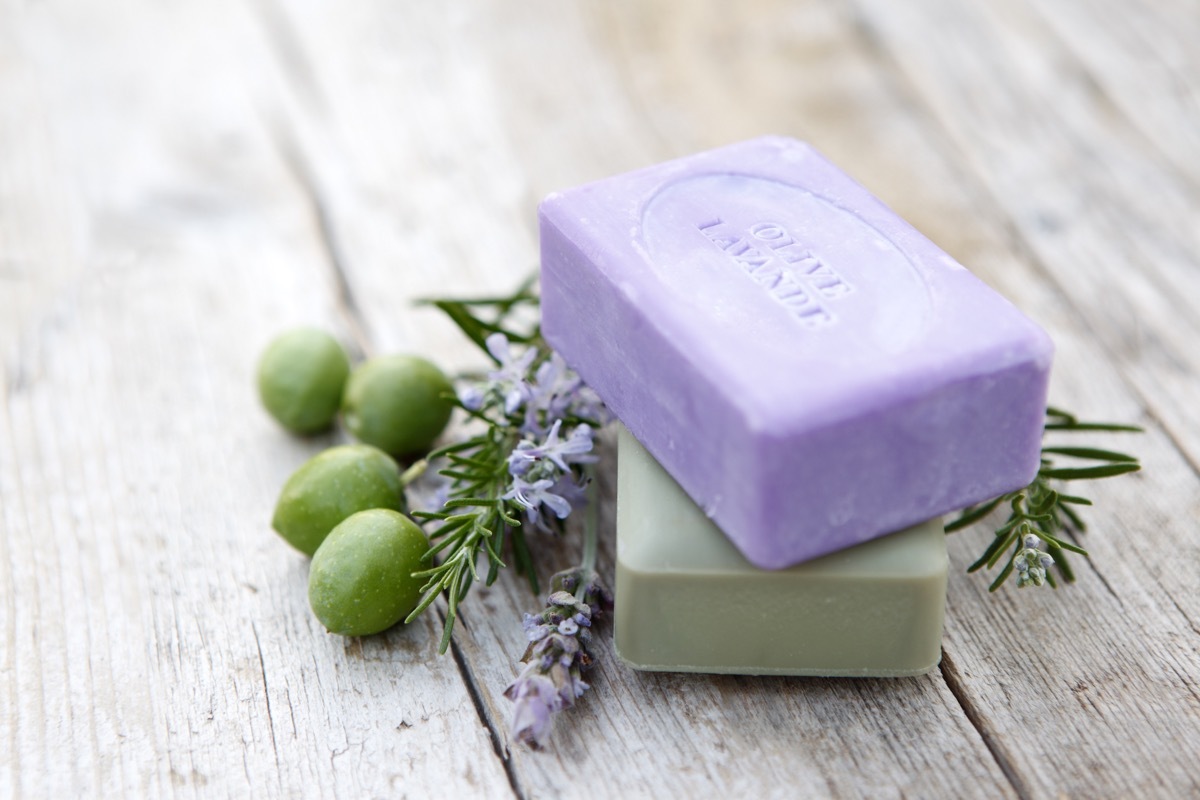 Bars of coloured handmade soaps with herbs and olives.