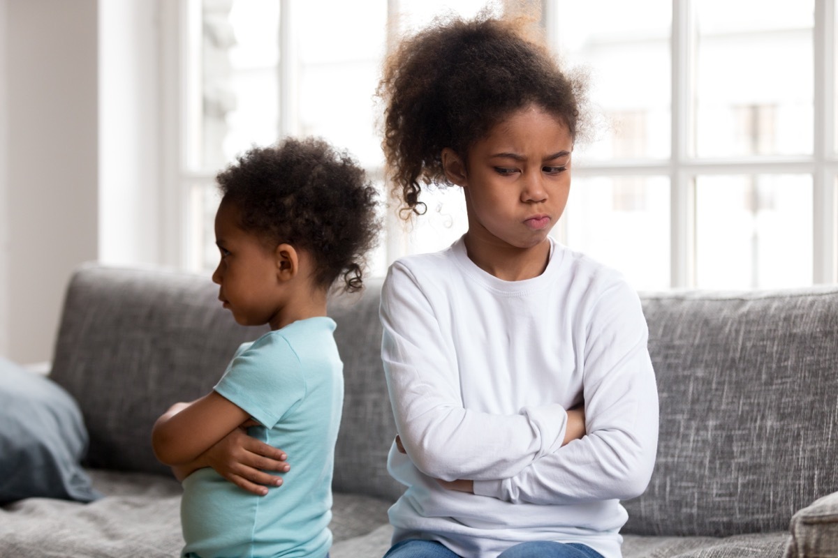 two young african american child siblings crossing arms and being angry with each other