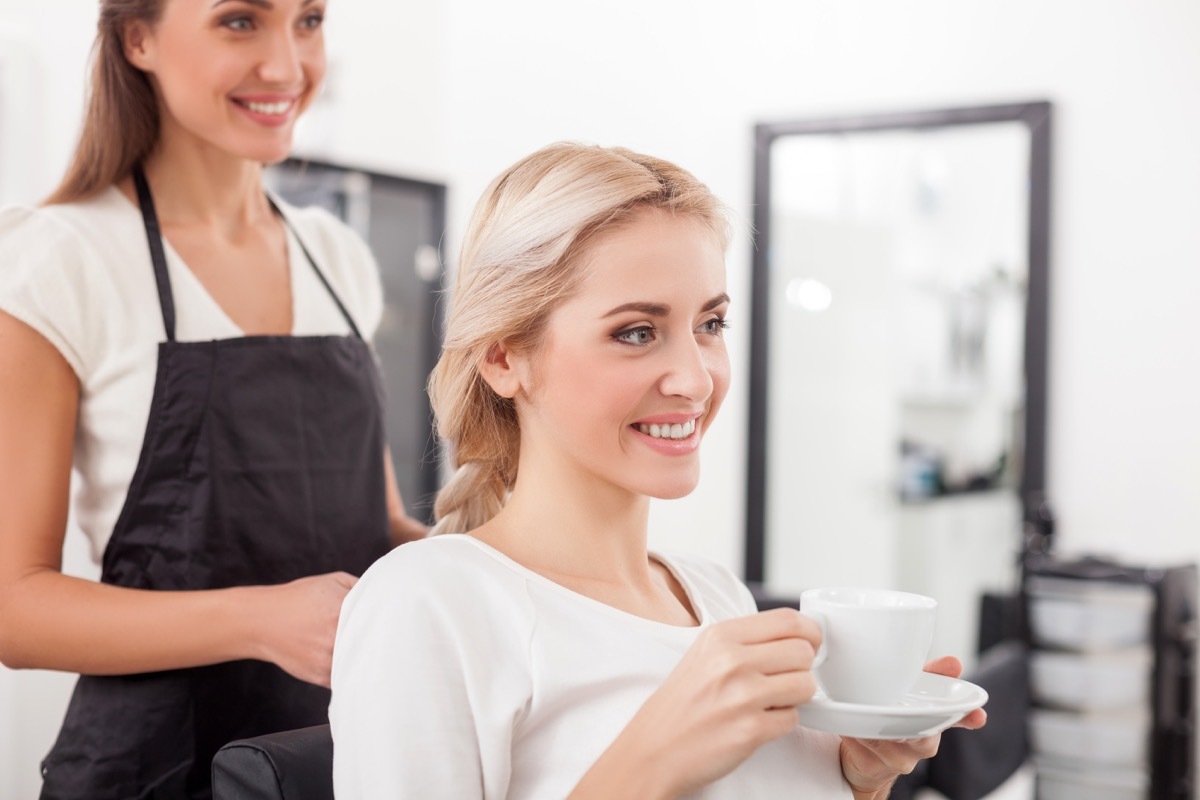 Woman having a cup of tea or coffee at hair salon