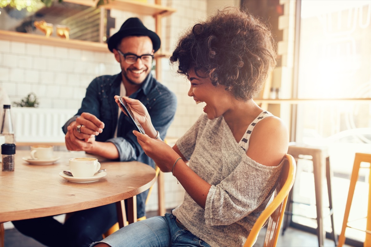 couple reading love jokes off their phone and laughing