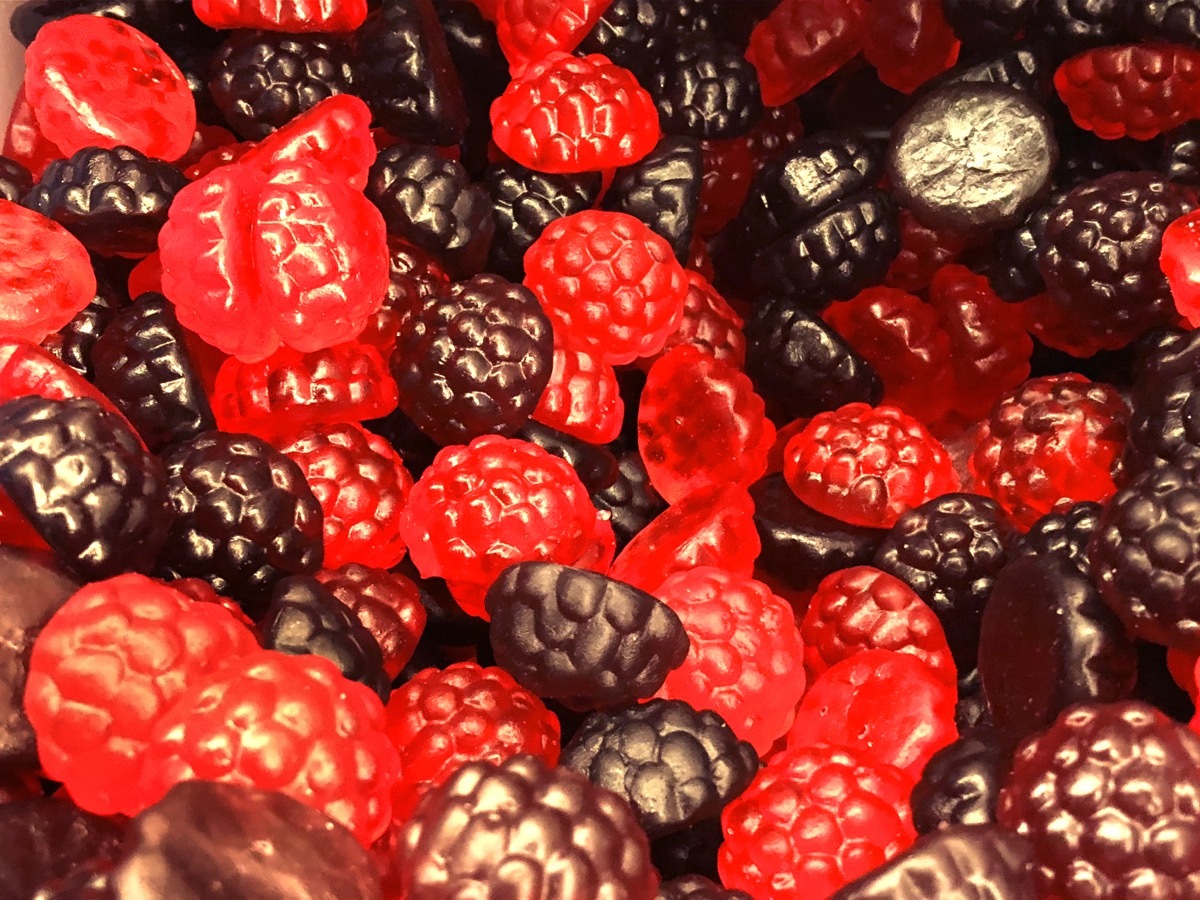 Stock photo of sweet shop pic and mix display of purple and red jelly sweet / gummy berry fruit shaped like blackberries and raspberries.