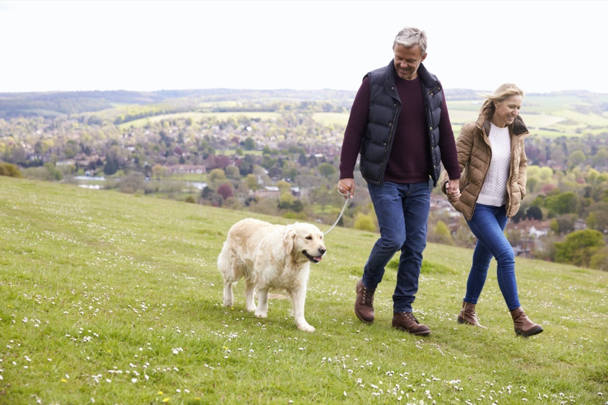 middle age couple walking their dog