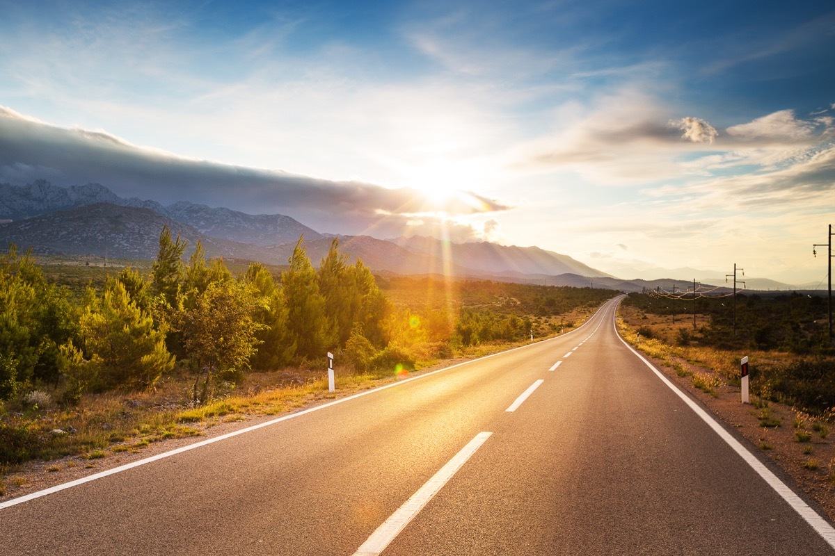 empty road with the sun in the background