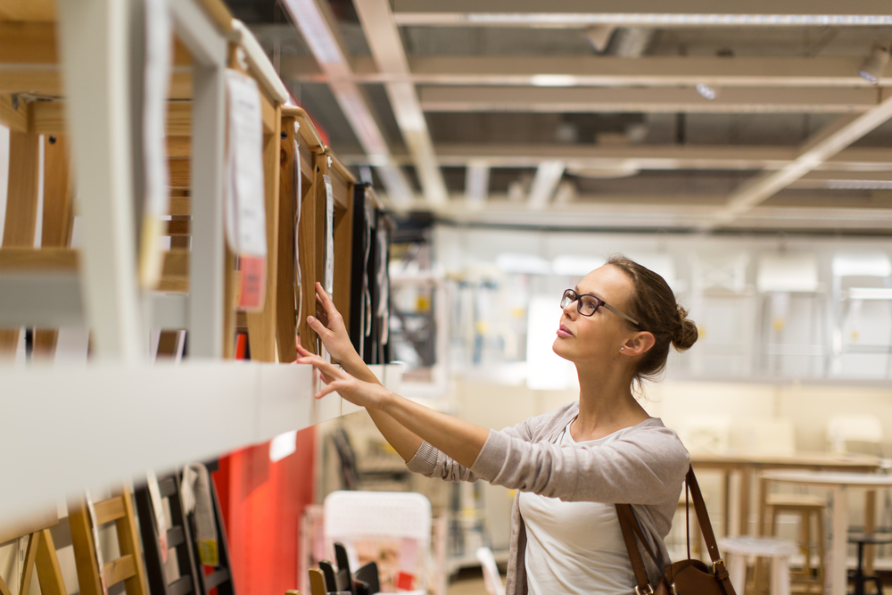 A young woman shopping for chairs in a furniture store