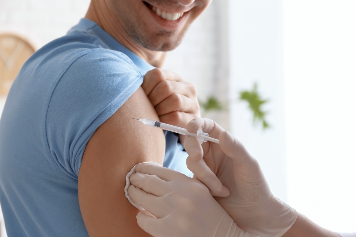 Doctor vaccinating male patient in clinic