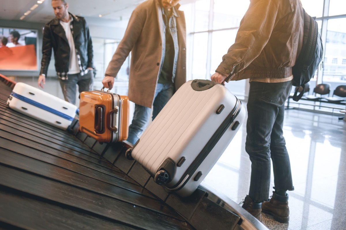 People grabbing bags from baggage claim