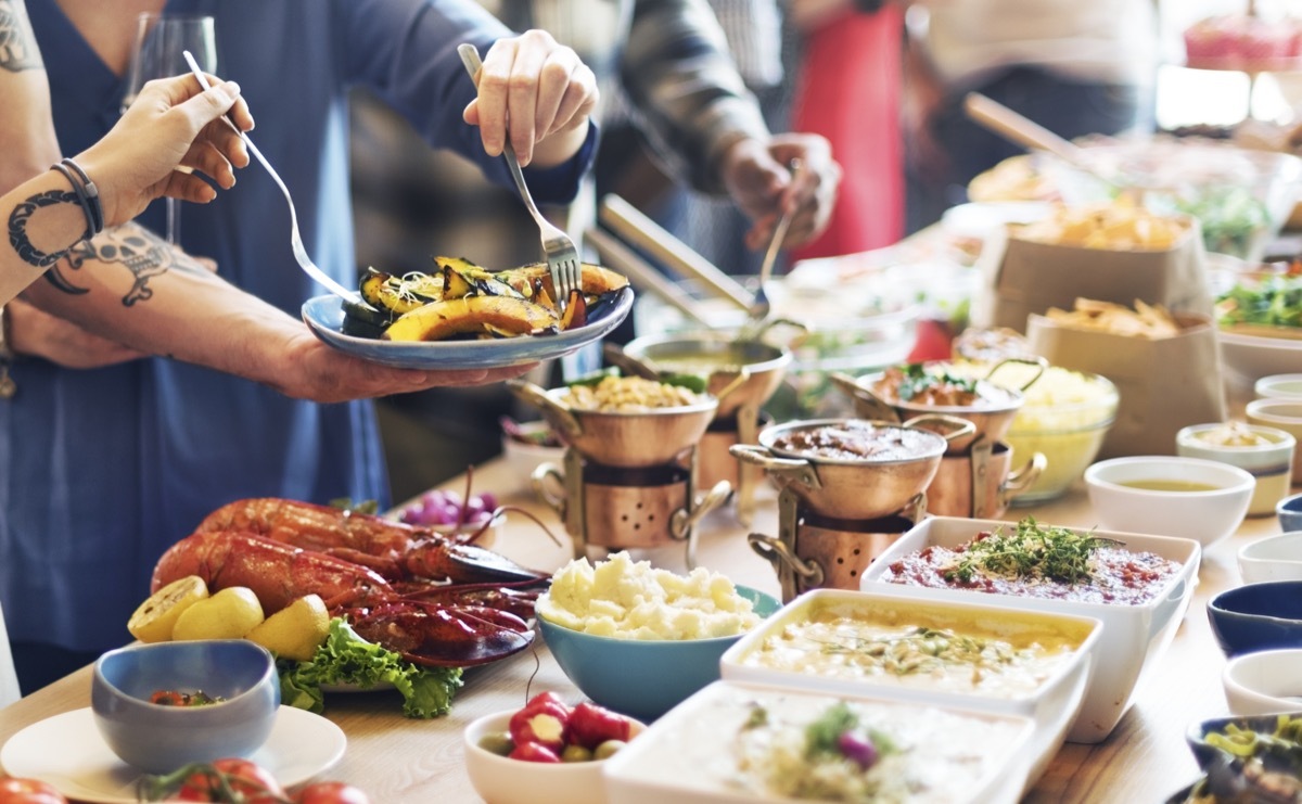 people serving themselves from holiday buffet table