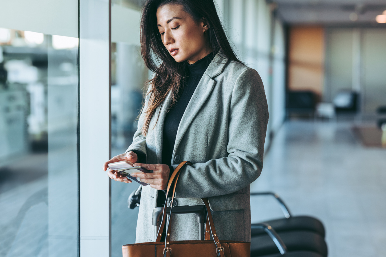 A woman using her phone in the airport