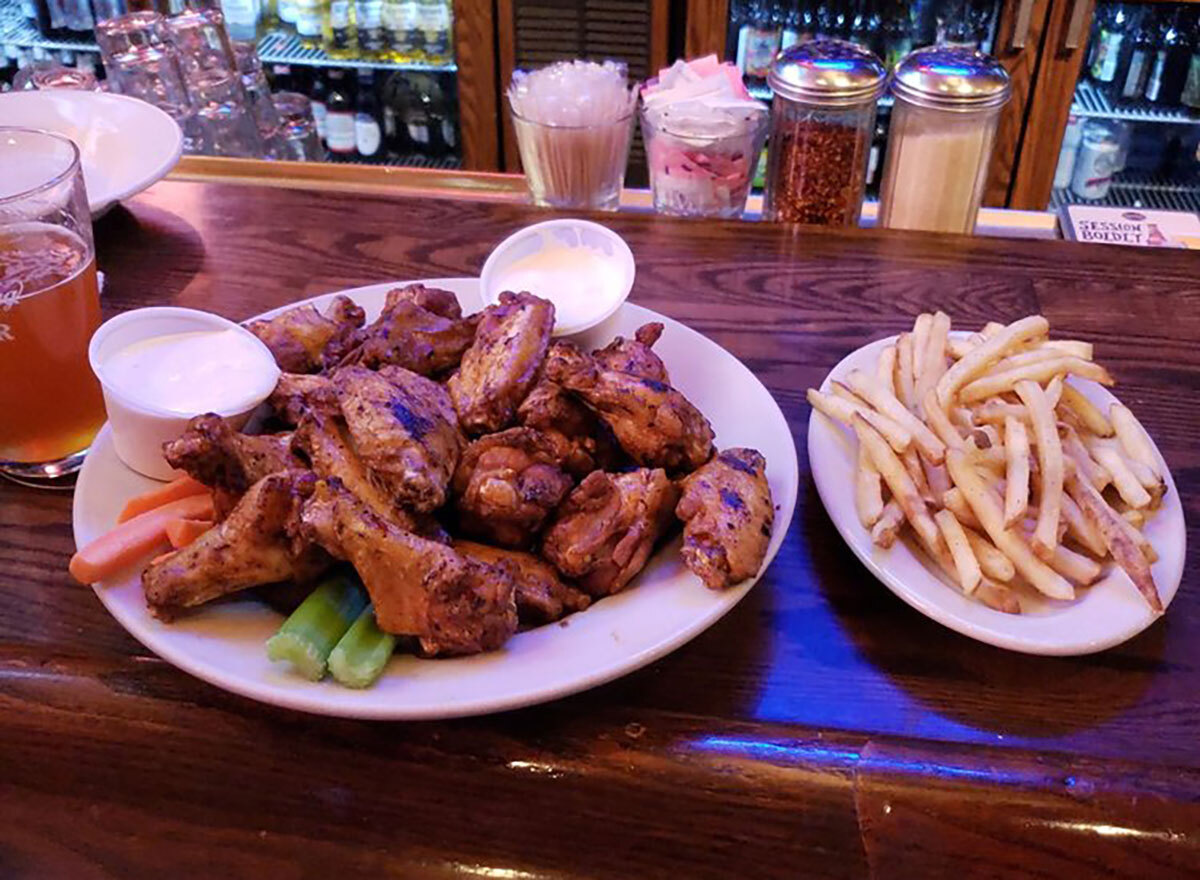 plate of chicken wings with dips and fries