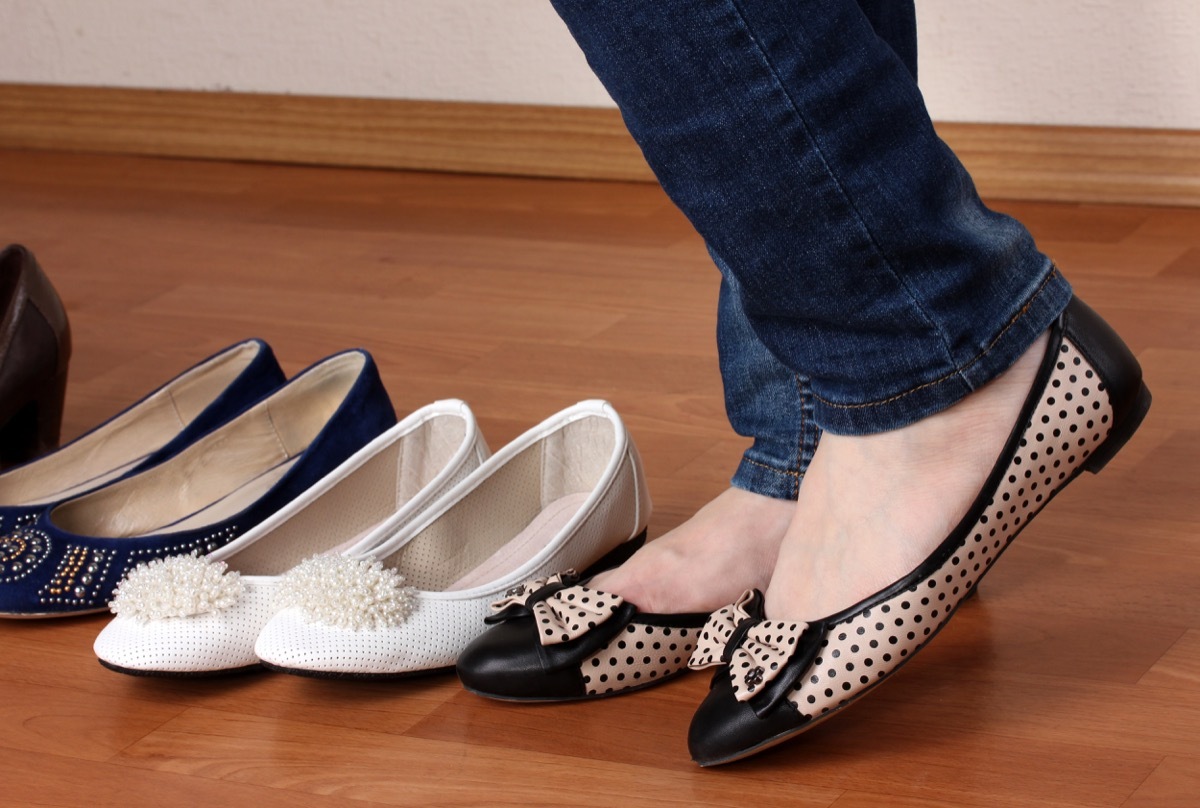 Woman in ballet flat shoes on wooden background