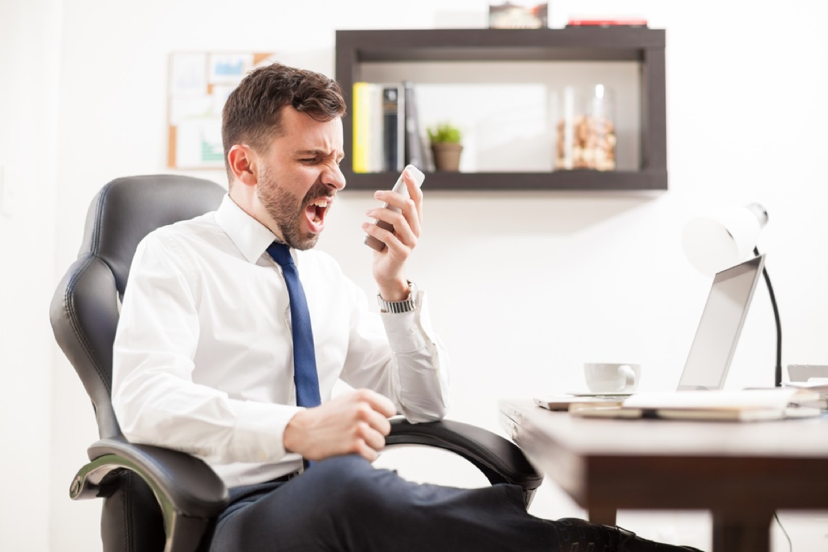 man shouting into phone signs of burnout