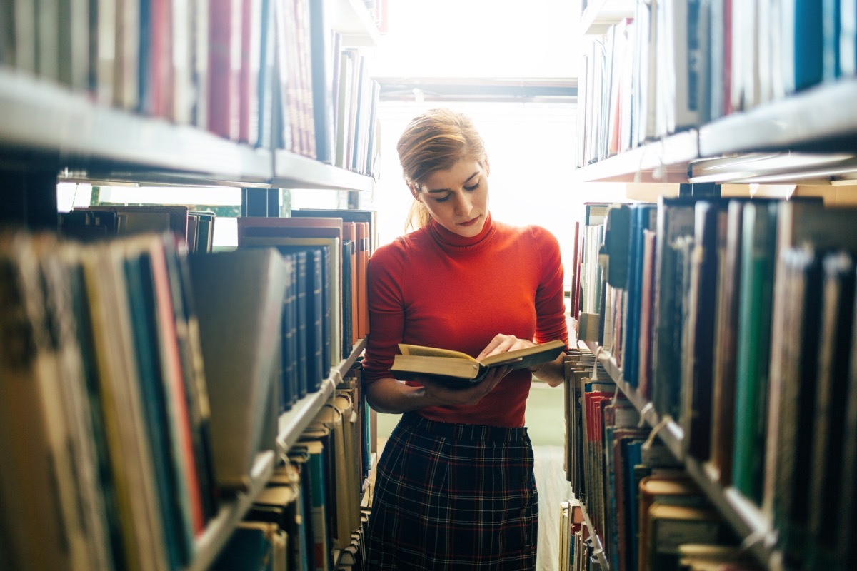 woman reading a book in a library