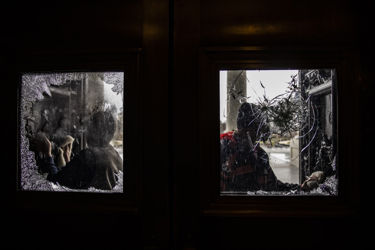 workers clean broken glass on doors at us capitol