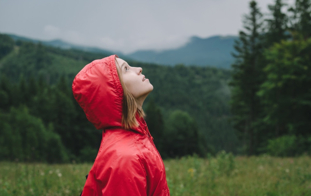 woman looking up at rain clouds